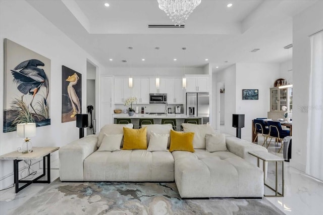 living area with a notable chandelier, recessed lighting, visible vents, marble finish floor, and a raised ceiling