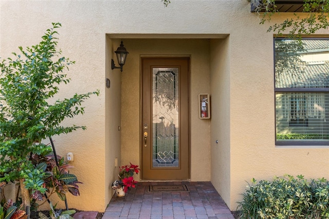 entrance to property featuring stucco siding