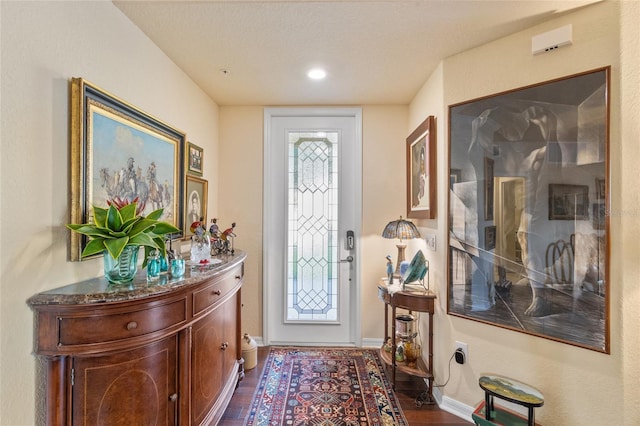 entrance foyer featuring dark wood finished floors, a textured ceiling, and baseboards