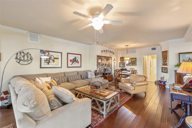 living area featuring ornamental molding, visible vents, hardwood / wood-style floors, and a ceiling fan