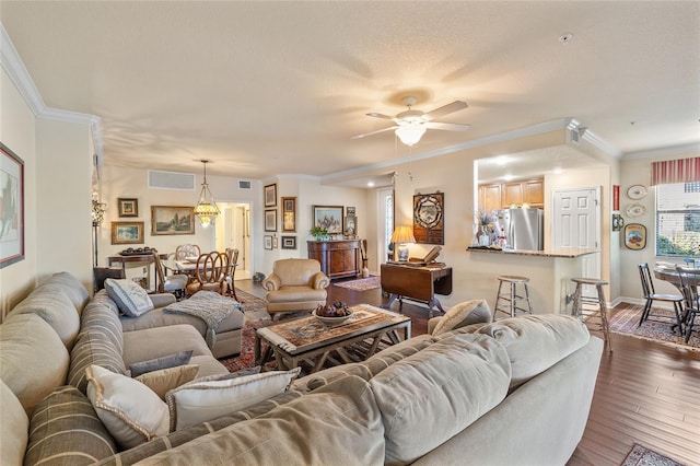 living room with visible vents, dark wood finished floors, and ornamental molding