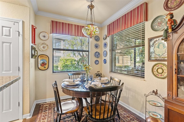 dining area with ornamental molding, baseboards, and wood finished floors