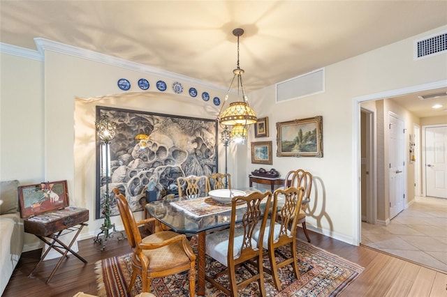 dining area with wood finished floors, visible vents, and baseboards