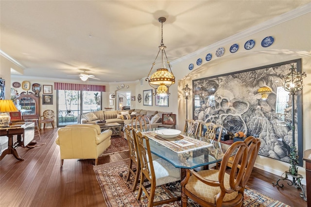 dining space featuring ceiling fan, baseboards, dark wood finished floors, and crown molding