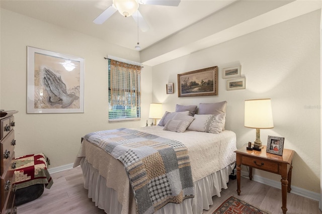 bedroom with a ceiling fan, baseboards, and wood finished floors