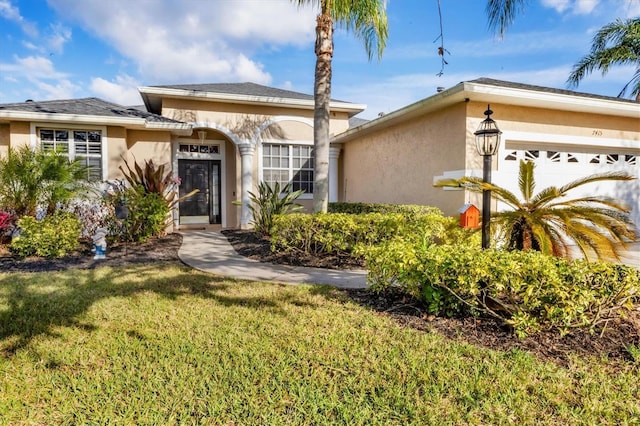 view of front of property with a front lawn, a garage, and stucco siding