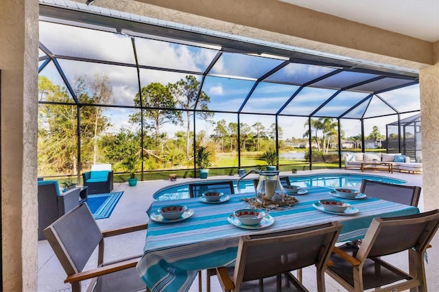 view of patio / terrace featuring a lanai, outdoor dining space, and an outdoor pool