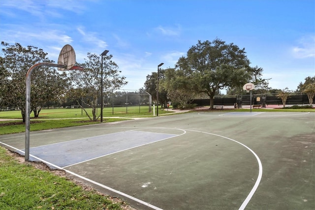 view of basketball court featuring community basketball court, a yard, and fence