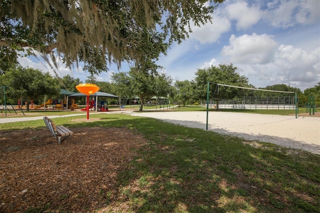 view of property's community featuring playground community, a yard, and volleyball court