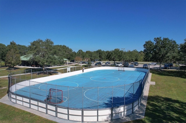 view of pool featuring community basketball court, fence, and a lawn