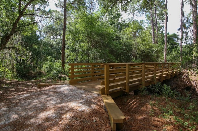 view of community with a forest view and a wooden deck