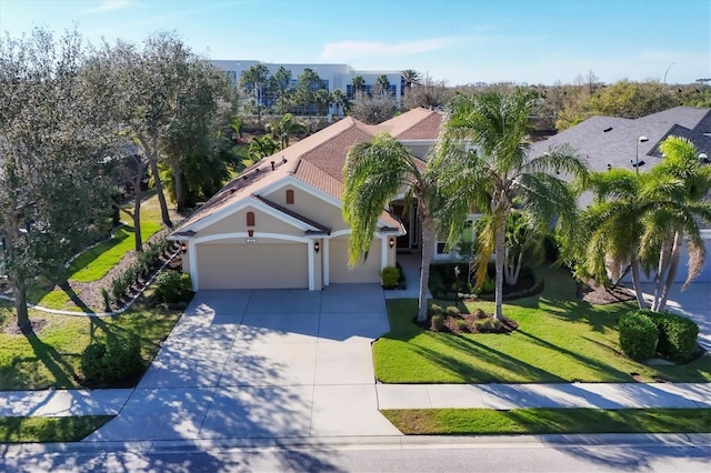 view of front of house with a garage, driveway, a front yard, and stucco siding