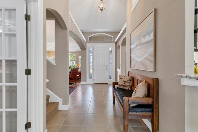 entryway with light tile patterned flooring and baseboards