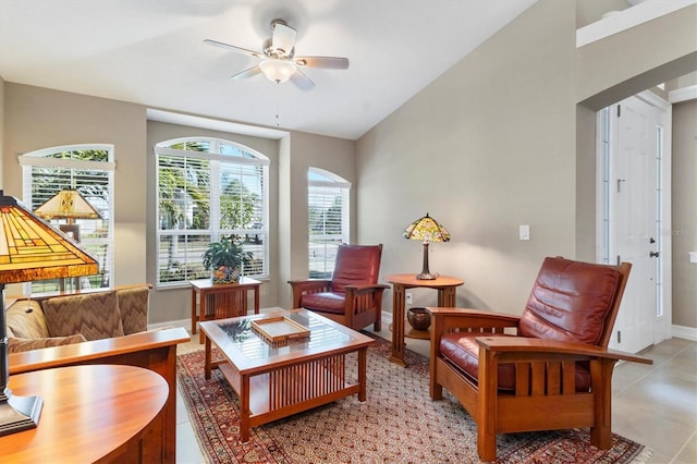 sitting room featuring lofted ceiling, light tile patterned floors, ceiling fan, and baseboards