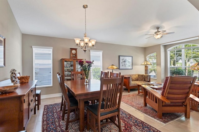 dining room with light tile patterned flooring, plenty of natural light, baseboards, and ceiling fan with notable chandelier