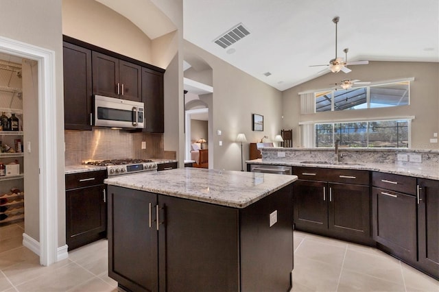 kitchen with dark brown cabinetry, a sink, visible vents, a kitchen island, and appliances with stainless steel finishes