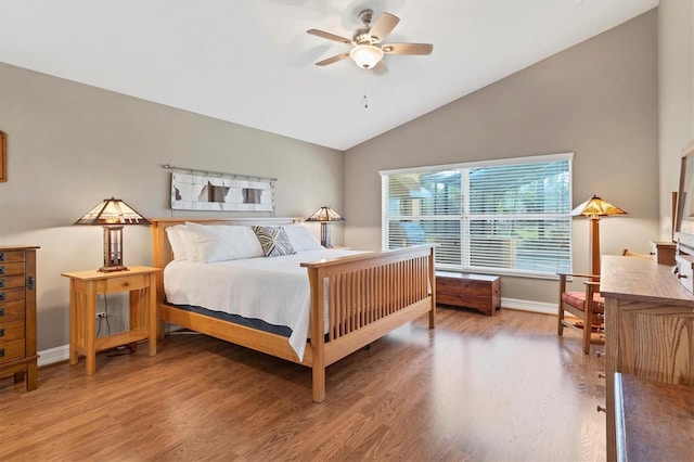 bedroom featuring a ceiling fan, vaulted ceiling, baseboards, and wood finished floors