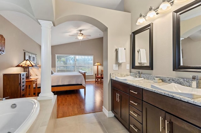 full bath with ensuite bath, decorative columns, a sink, and tile patterned floors