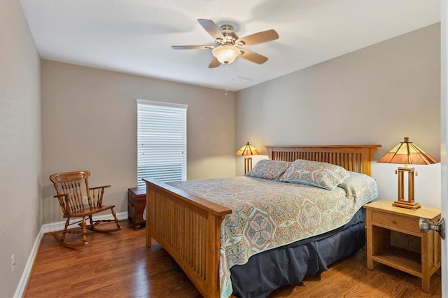 bedroom featuring dark wood-style floors, a ceiling fan, and baseboards