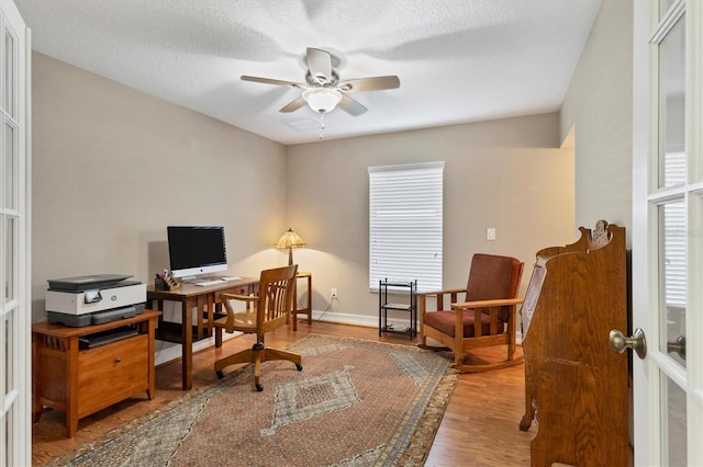 office area with ceiling fan, a textured ceiling, wood finished floors, and baseboards