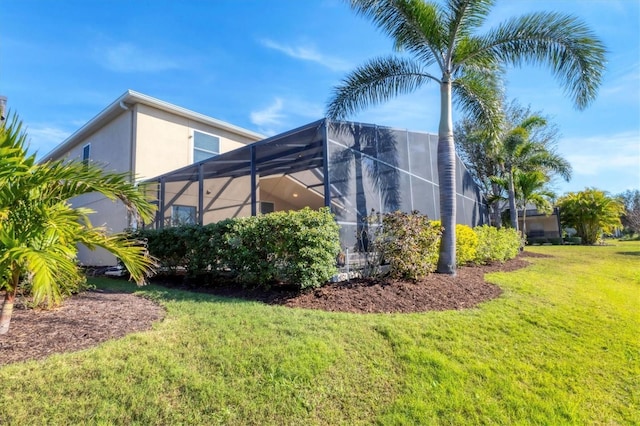 view of property exterior featuring a yard, a lanai, and stucco siding