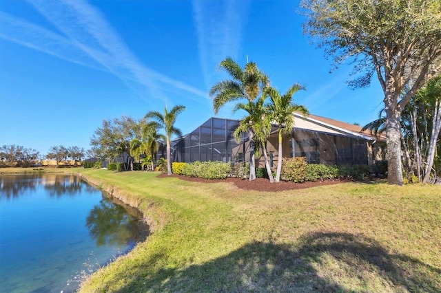 exterior space featuring a lanai, a water view, and a lawn