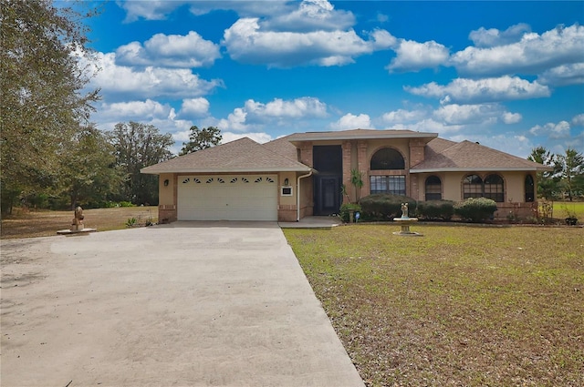 view of front of property featuring an attached garage, brick siding, driveway, and a front yard