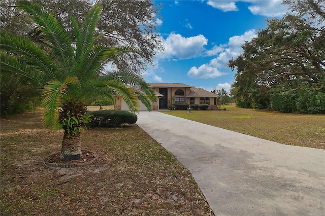 view of front facade with a garage, a front yard, and driveway