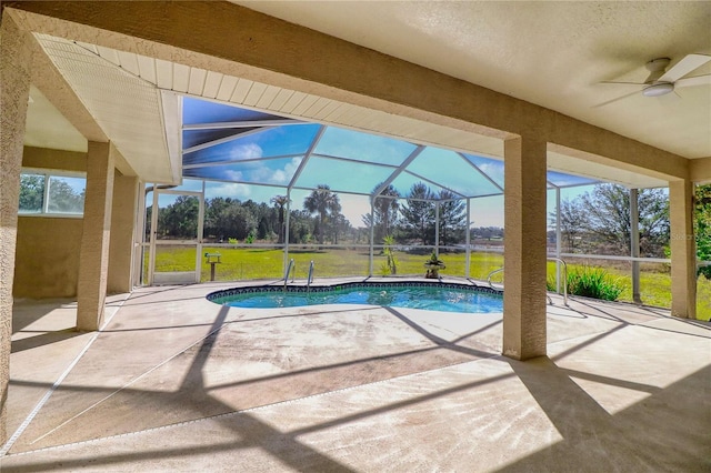 outdoor pool featuring ceiling fan, a patio, a lawn, and glass enclosure