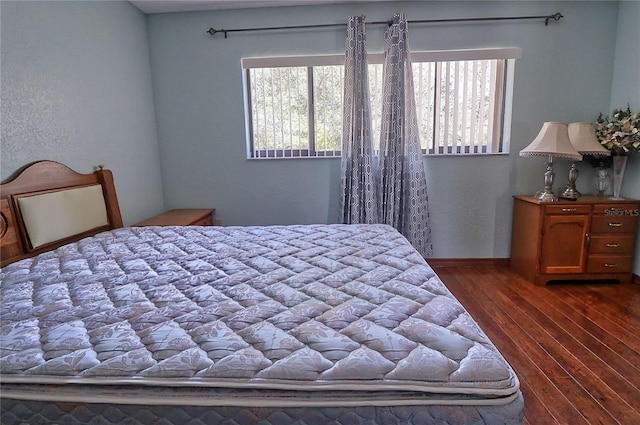 bedroom with dark wood-style flooring