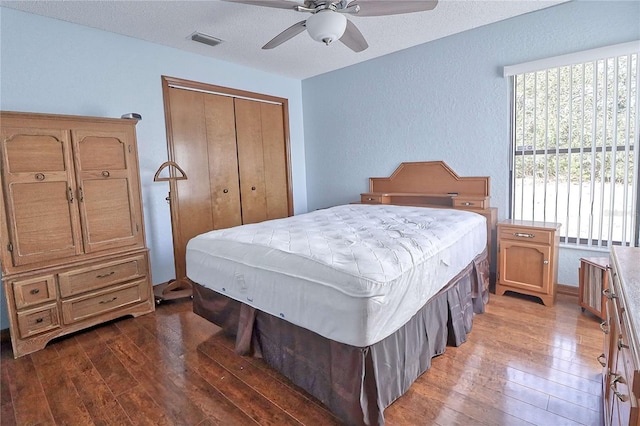 bedroom with a ceiling fan, a closet, visible vents, and hardwood / wood-style flooring