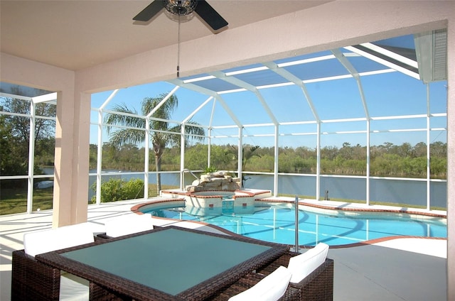 view of pool with glass enclosure, a patio, and a water view