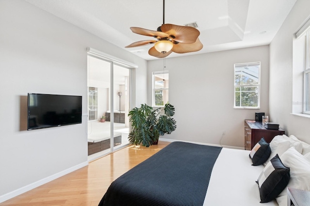 bedroom featuring visible vents, baseboards, light wood-style flooring, ceiling fan, and access to exterior