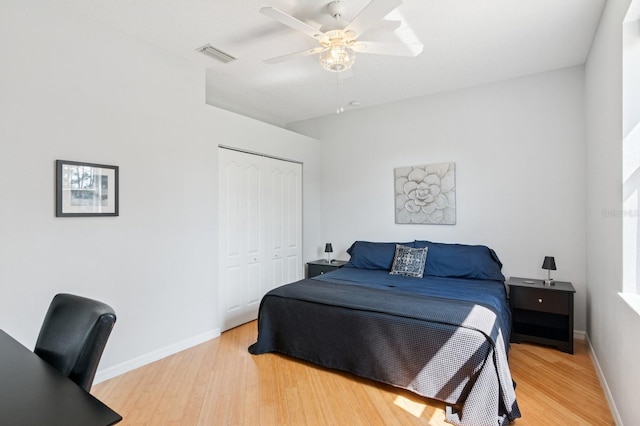 bedroom with light wood-type flooring, a closet, visible vents, and baseboards