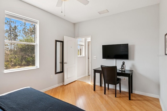 bedroom with light wood-style floors, baseboards, and a ceiling fan