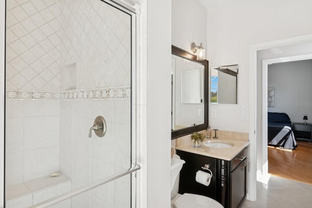 full bath with toilet, tiled shower, and vanity