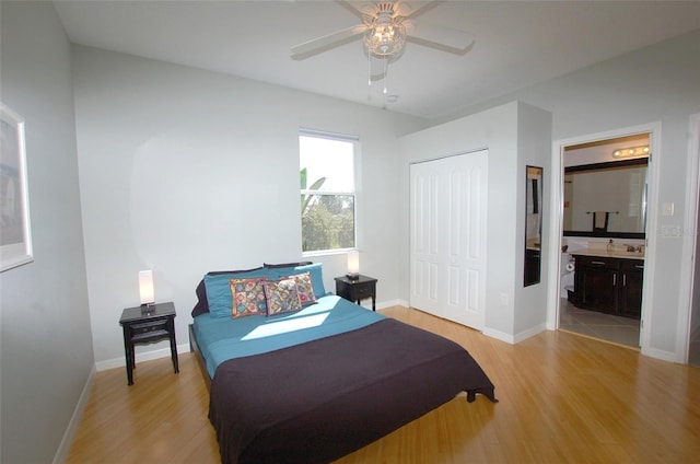 bedroom featuring baseboards, a closet, connected bathroom, and light wood-style floors