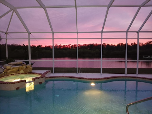 view of pool with a lanai, a water view, a pool with connected hot tub, and a patio