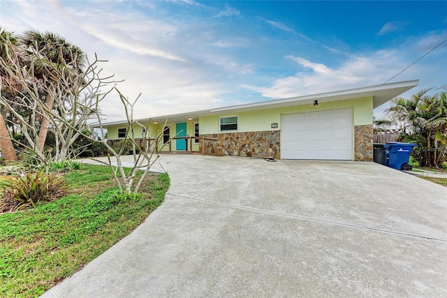 ranch-style house with a garage, stone siding, driveway, and stucco siding