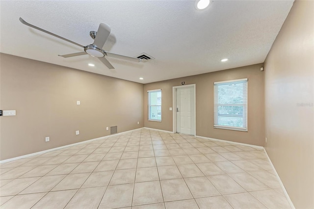 unfurnished room with a textured ceiling, ceiling fan, and visible vents