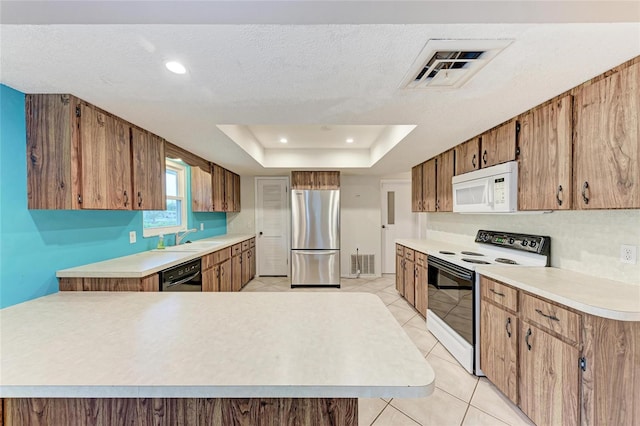 kitchen featuring electric range, light countertops, white microwave, and freestanding refrigerator