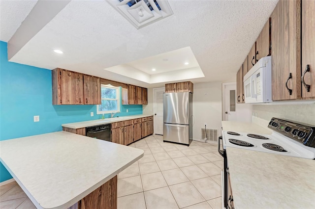 kitchen with electric range, light countertops, white microwave, and freestanding refrigerator