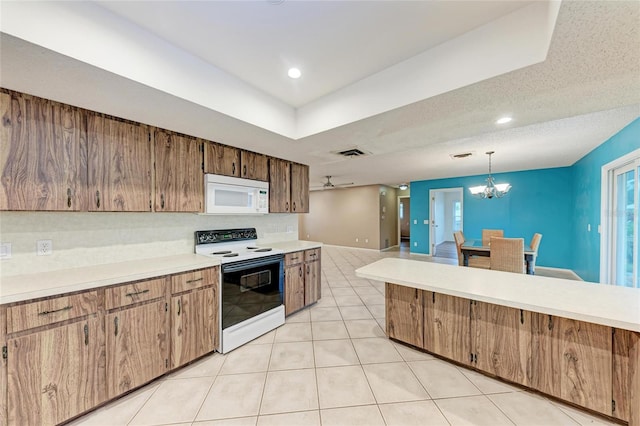 kitchen featuring white microwave, range with electric cooktop, light countertops, and pendant lighting