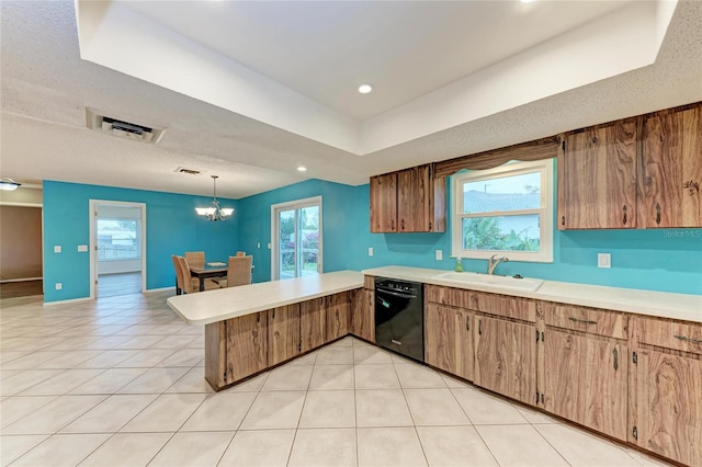 kitchen with black dishwasher, visible vents, light countertops, hanging light fixtures, and a sink