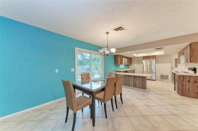 dining area featuring an inviting chandelier, light tile patterned floors, visible vents, and a textured ceiling