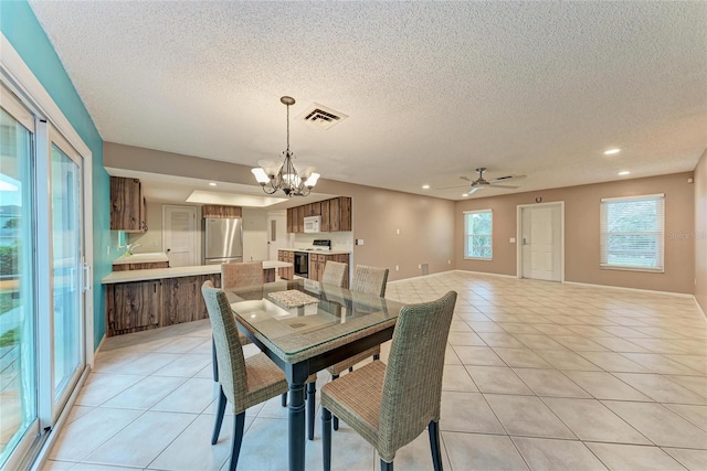 dining area with light tile patterned floors, visible vents, a textured ceiling, and recessed lighting