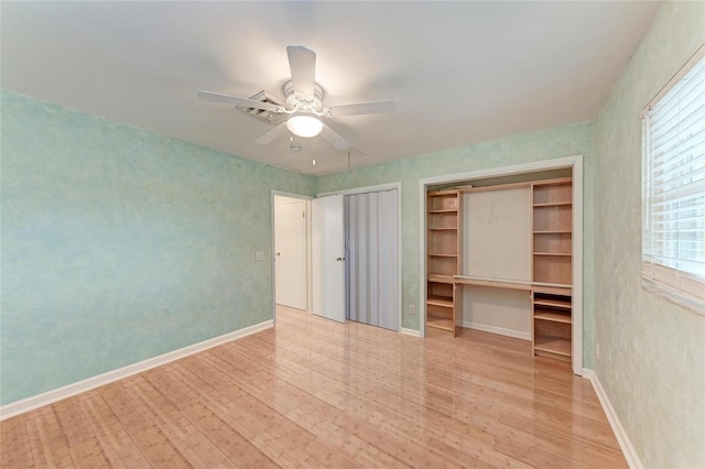 unfurnished bedroom with a ceiling fan, two closets, light wood-style flooring, and baseboards