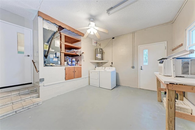 washroom with water heater, ceiling fan, a textured ceiling, separate washer and dryer, and laundry area