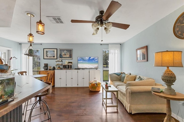 living area featuring dark wood-style floors, visible vents, and a ceiling fan