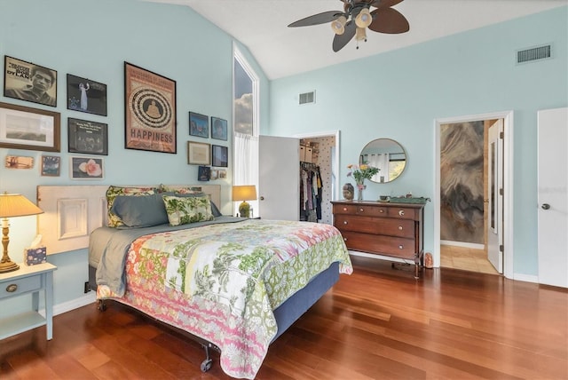 bedroom featuring a walk in closet, visible vents, and wood finished floors